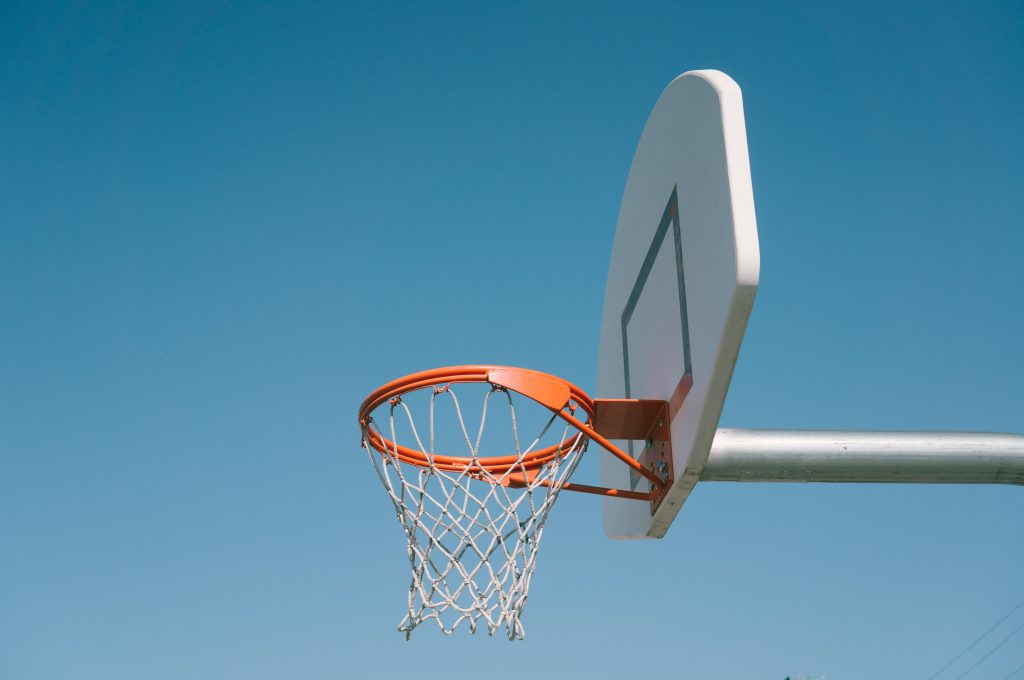 basketball hoop backboard net against bright blue sky