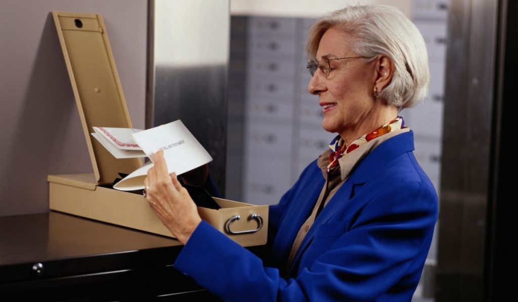 a lady holding important documents stored in a safe deposit box